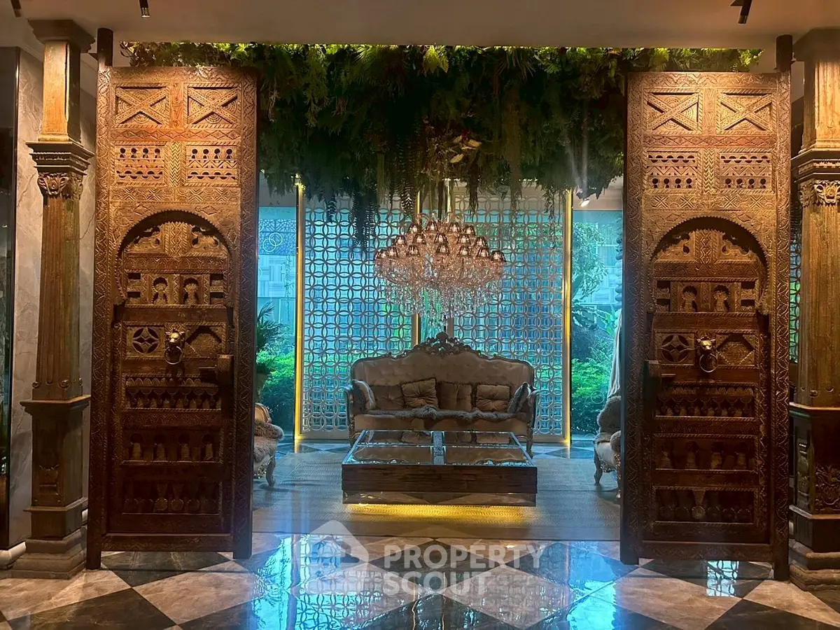 Luxurious living room with ornate wooden doors and elegant chandelier