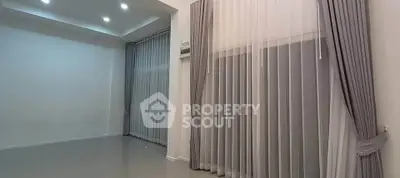 Spacious empty room with elegant curtains and modern lighting, perfect for customization.
