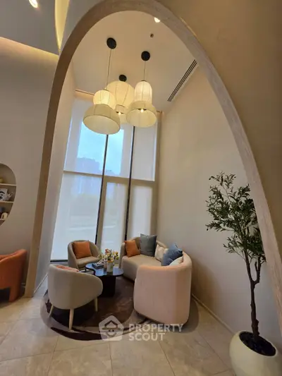 Elegant living room with high ceilings, modern furniture, and large windows offering natural light.