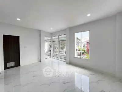 Spacious modern living room with large windows and balcony access, featuring sleek marble flooring.