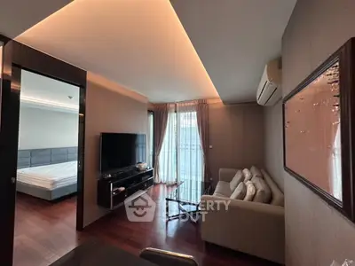 Modern living room with sleek design and cozy ambiance, featuring a large TV and comfortable seating area.