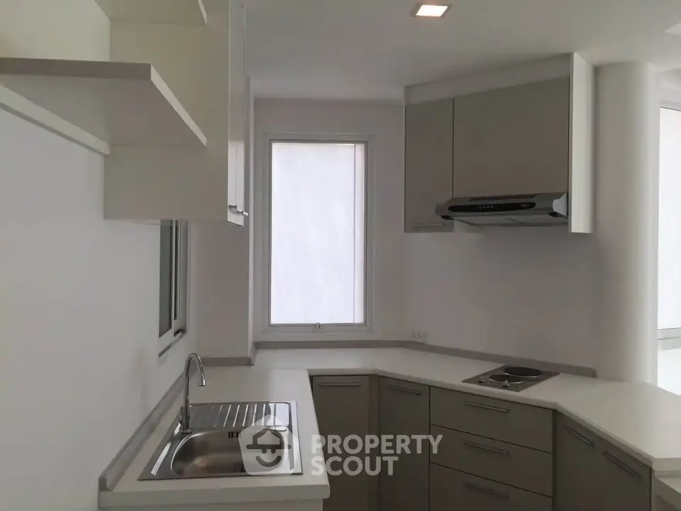 Modern kitchen with sleek cabinetry and built-in stove in a minimalist design.