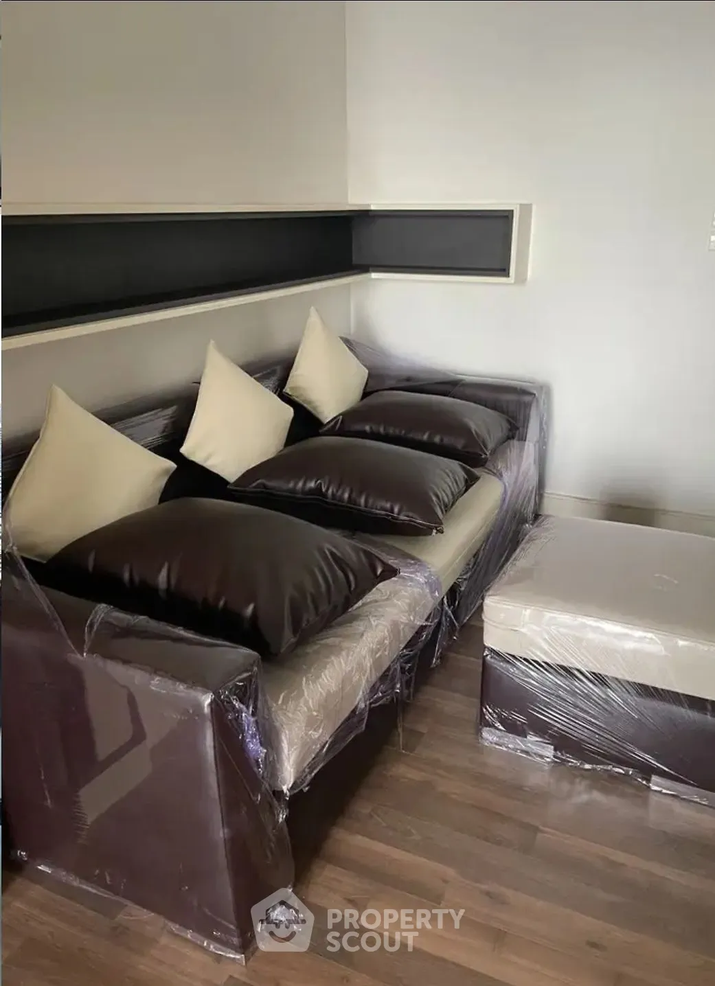 Modern living room with sleek leather sofa and wooden flooring, perfect for stylish urban living.