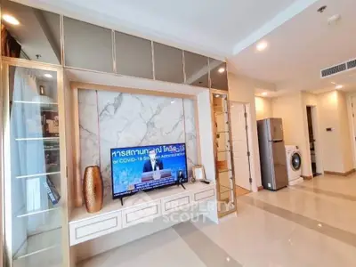 Modern living room with TV, marble accent wall, and sleek appliances in a stylish apartment.