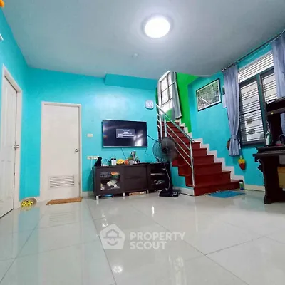 Bright living room with modern staircase and vibrant turquoise walls, perfect for stylish urban living.