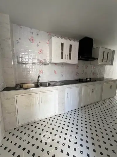 Spacious kitchen with floral backsplash and modern cabinetry