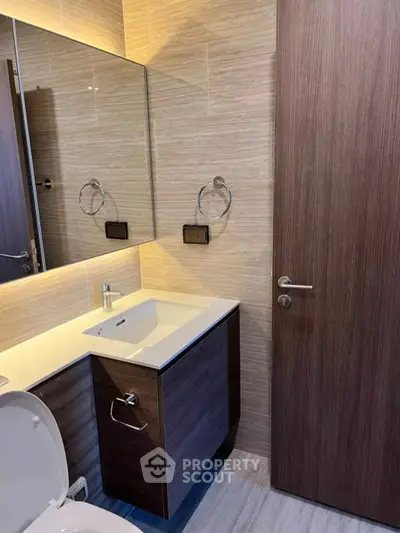 Modern bathroom with sleek wooden cabinetry and elegant fixtures