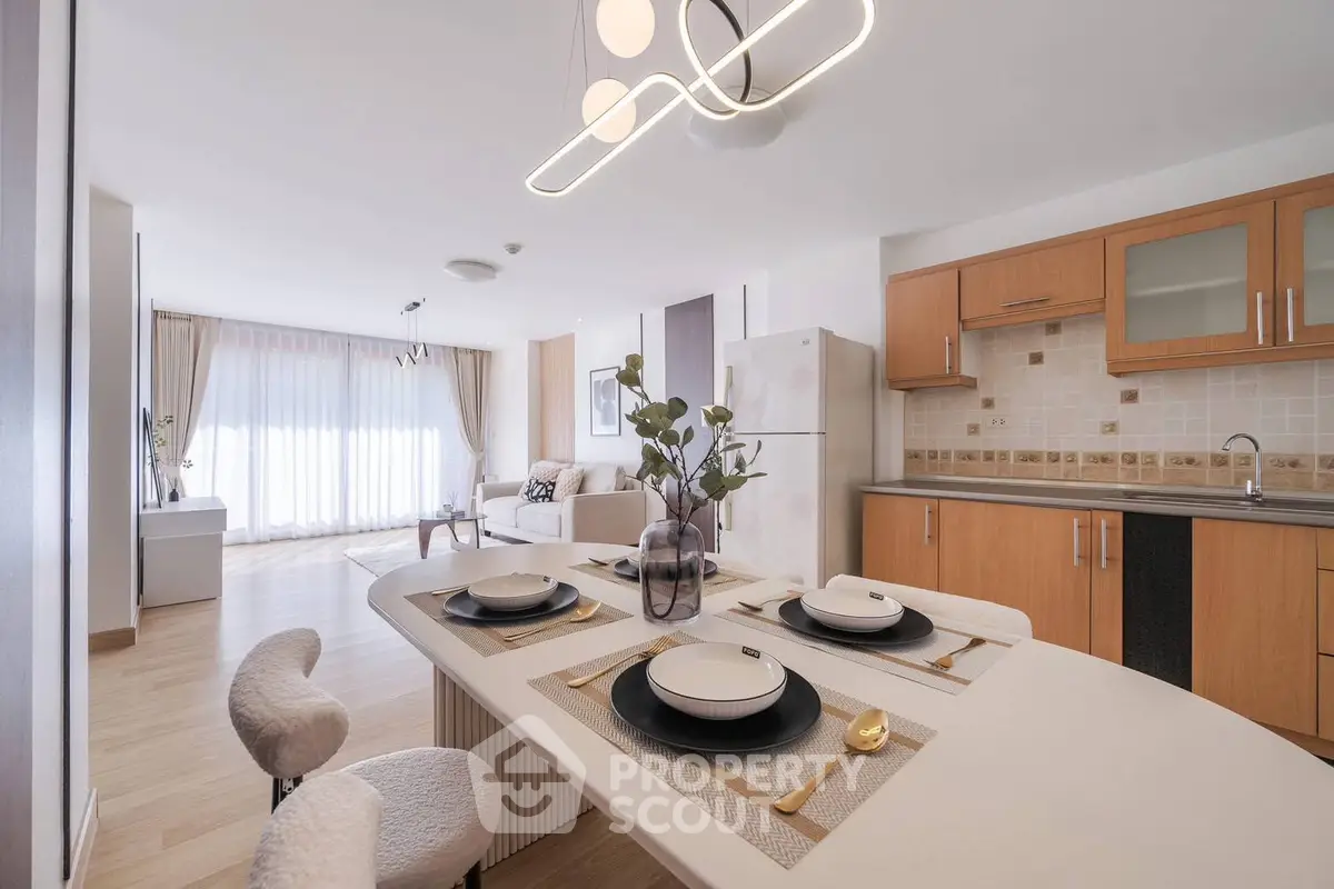 Spacious open-plan kitchen and living room with modern decor and natural light.