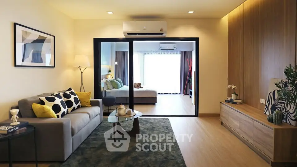 Modern living room with stylish decor and open view to bedroom