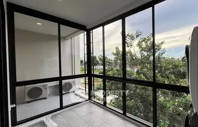 Spacious balcony with large windows and scenic view, perfect for relaxation.