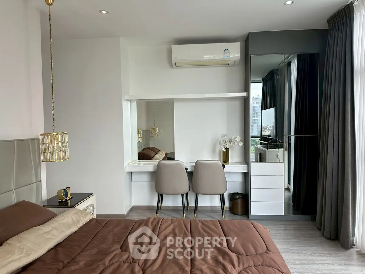 Modern bedroom with stylish decor and mirrored wardrobe in a luxury apartment.