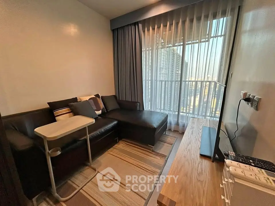 Modern living room with stylish furniture and large window offering city view