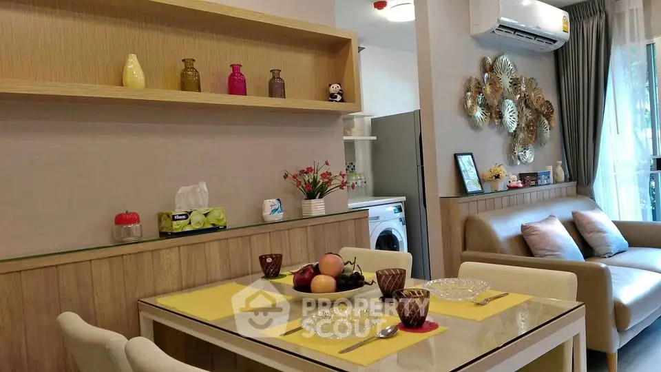 Modern living room with dining area and washing machine, featuring stylish decor and natural light.