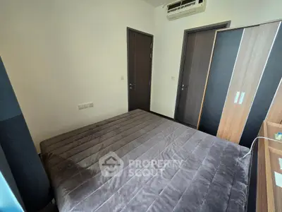 Cozy bedroom with modern wardrobe and air conditioning, perfect for a comfortable living experience.