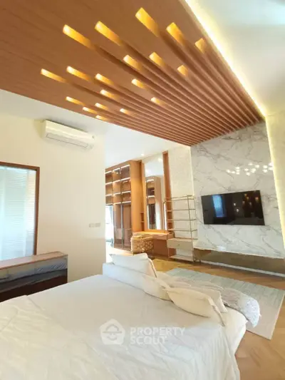 Luxurious bedroom with modern design, featuring a stylish ceiling and marble accent wall with TV.