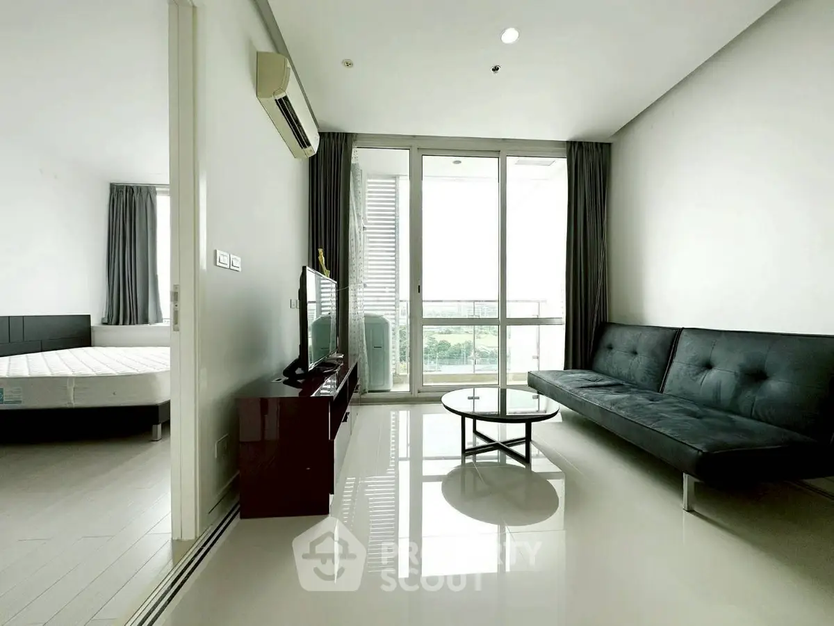 Modern living room with sleek furniture and large windows offering natural light and city views.