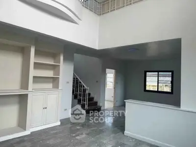 Spacious modern living area with elegant staircase and built-in shelving