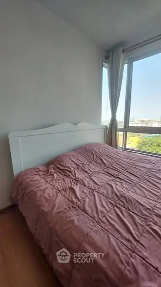 Cozy bedroom with large window offering a scenic view, featuring a comfortable bed and elegant curtains.