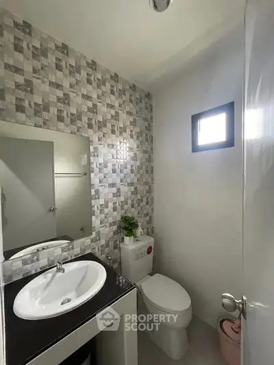 Modern bathroom with stylish tile wall and sleek fixtures