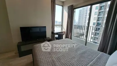 Modern bedroom with city view and balcony access in high-rise apartment