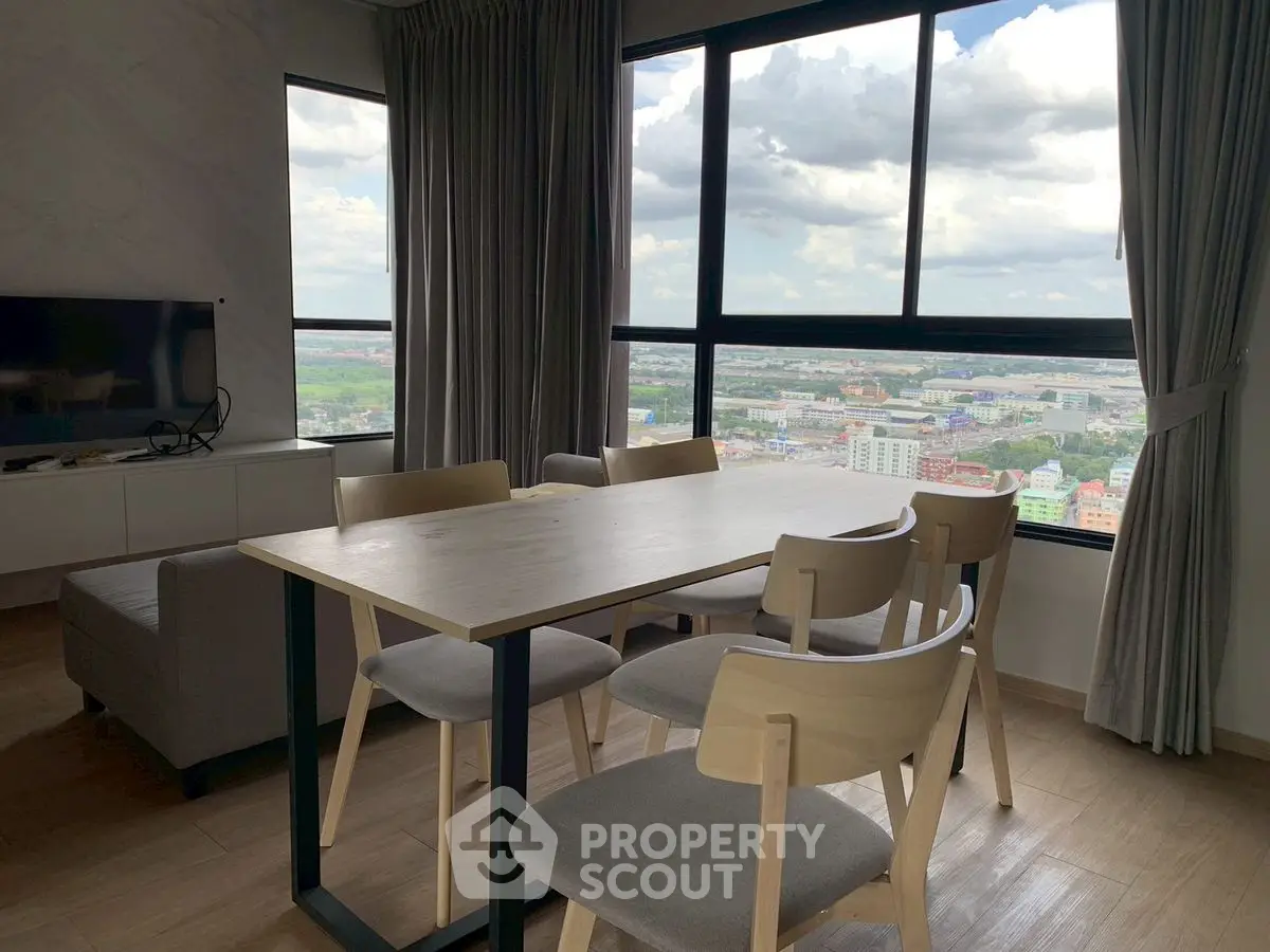Modern living room with panoramic city view and stylish dining area.