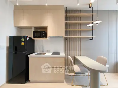 Modern kitchen with sleek cabinetry, integrated appliances, and stylish dining area in a contemporary apartment.