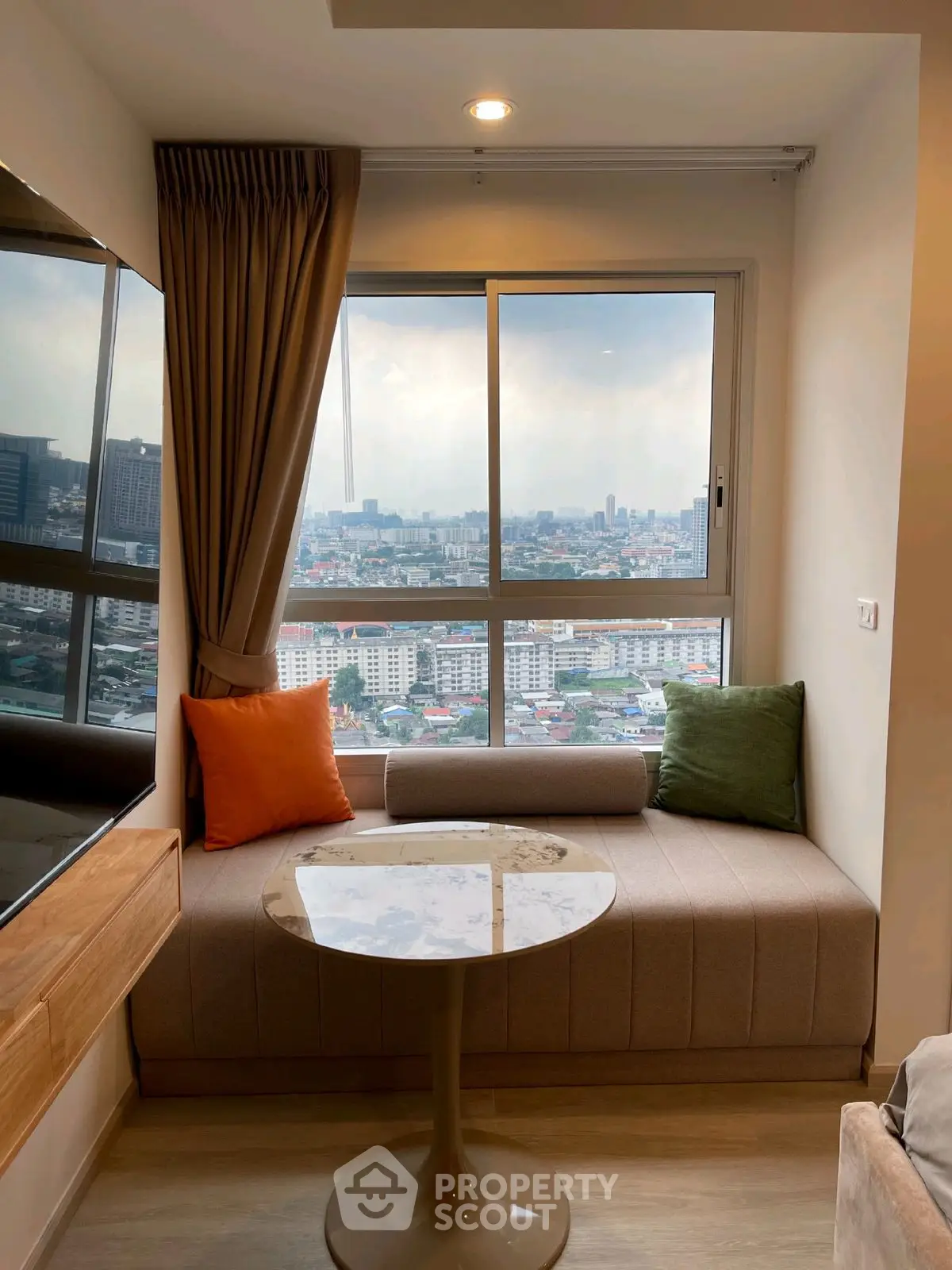 Cozy living room with panoramic city view and stylish seating area.