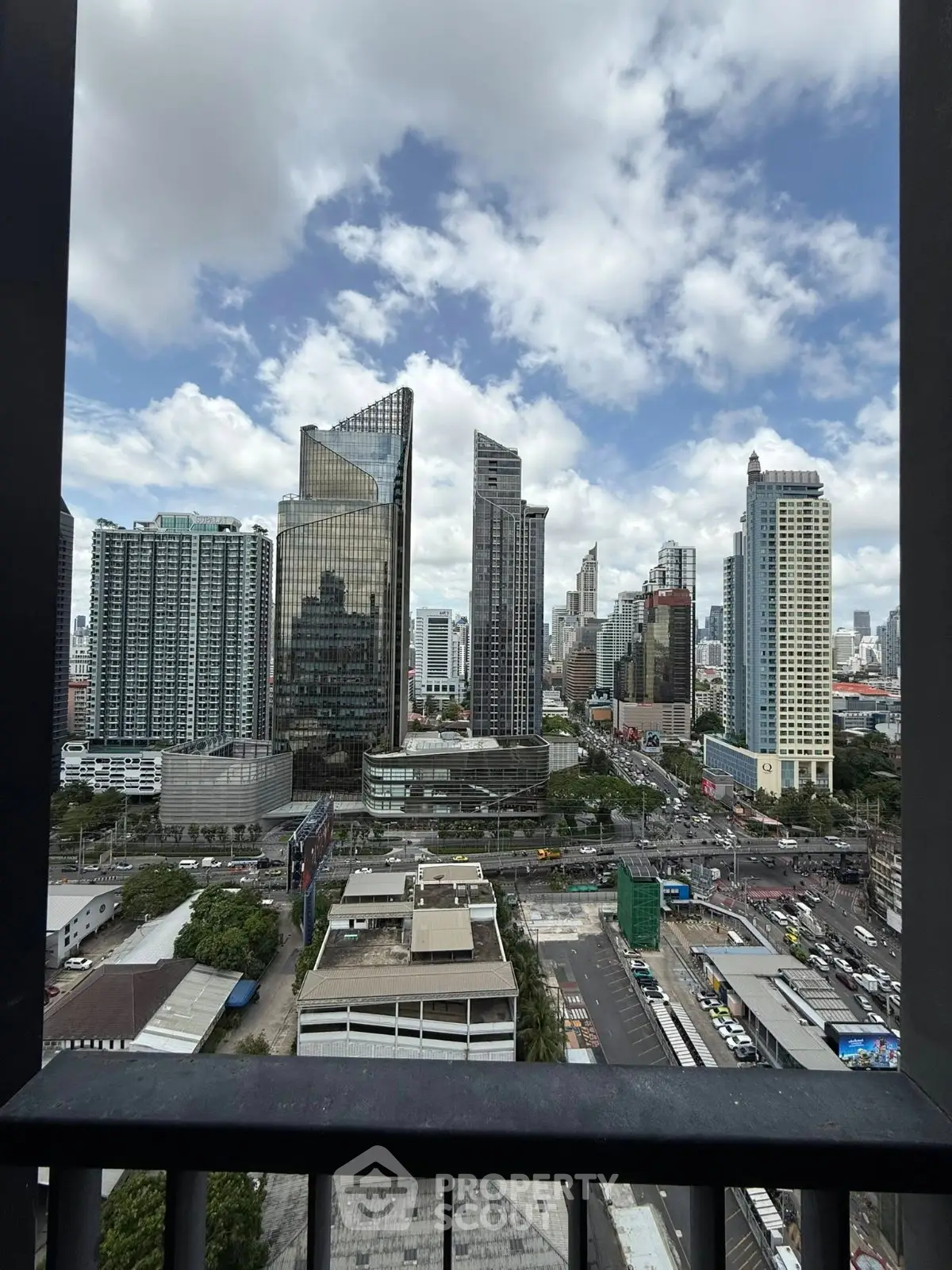 Stunning cityscape view from a high-rise balcony showcasing modern skyscrapers and bustling urban life.