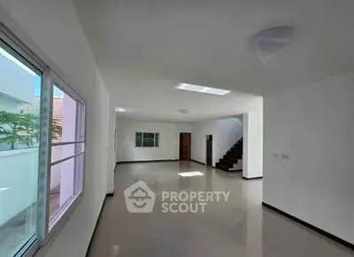 Spacious unfurnished living room with natural light and staircase in modern home