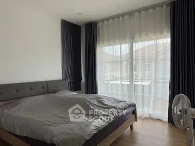 Spacious bedroom with large window and modern decor