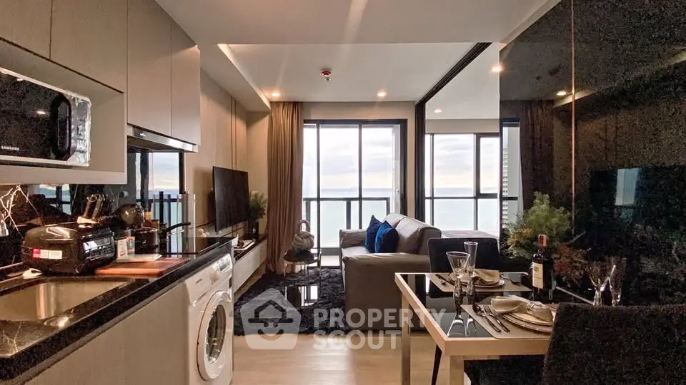 Modern living room with ocean view, sleek kitchen, and stylish decor