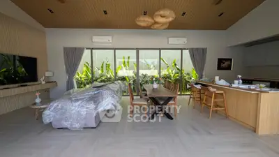 Spacious open-plan living room with modern decor and lush garden view.