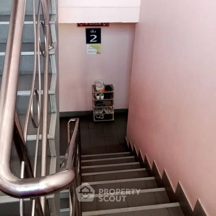 Staircase in residential building with shoe rack on landing