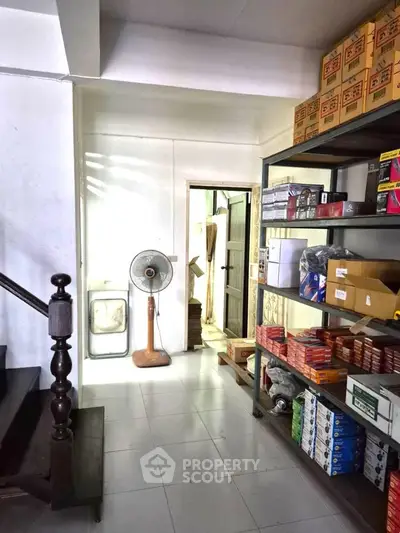 Spacious storage room with organized shelves and a fan, ideal for efficient inventory management.