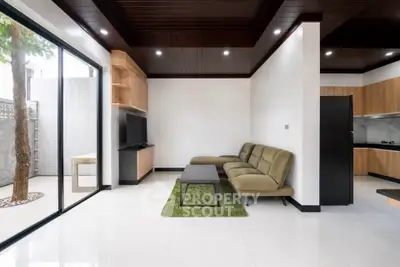 Modern living room with sleek design and open layout, featuring a cozy sofa and large sliding glass doors.