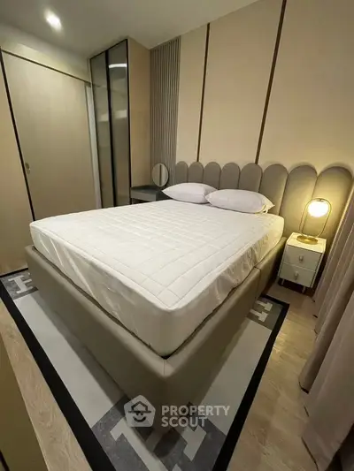 Modern bedroom with stylish bed and ambient lighting in a cozy apartment.