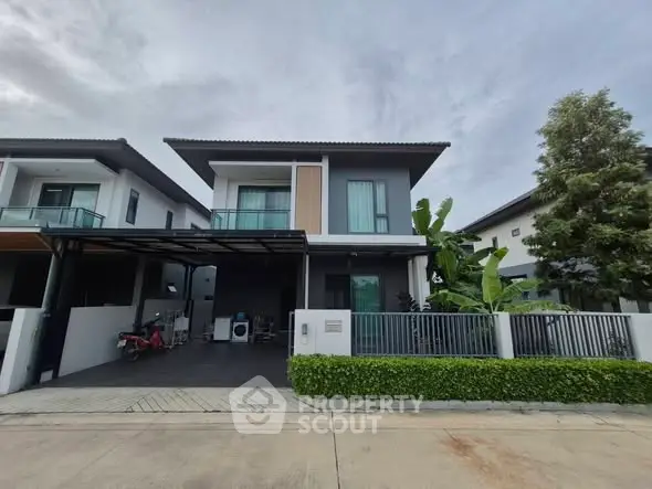 Modern two-story house with driveway and lush greenery
