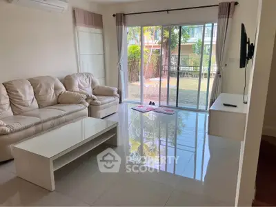 Spacious living room with modern furniture and garden view, perfect for relaxation and entertainment.