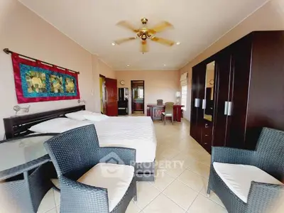 Spacious bedroom with modern furniture and ceiling fan, ideal for comfort and relaxation.