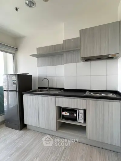 Modern kitchen with sleek cabinetry and appliances in a stylish apartment.