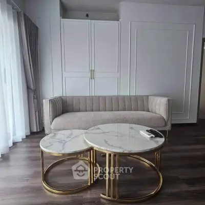 Elegant living room with modern sofa and marble coffee tables, perfect for stylish urban living.