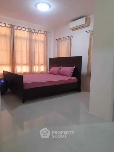 Spacious bedroom with elegant bed and natural light, perfect for relaxation.