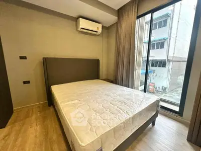 Modern bedroom with large window and air conditioning in urban apartment