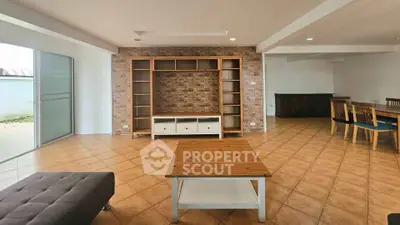 Spacious living room with brick accent wall and modern furniture, perfect for family gatherings.