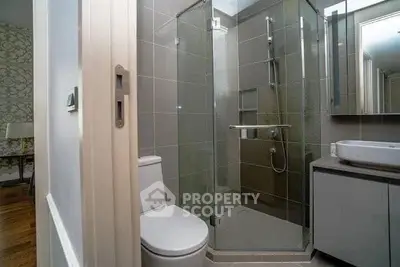 Modern bathroom with glass shower enclosure and sleek fixtures in a stylish apartment.