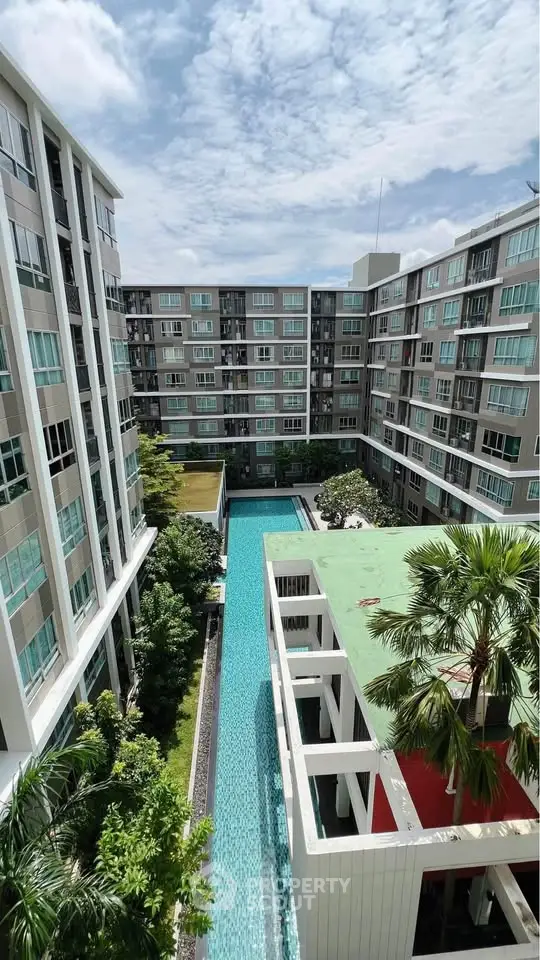 Modern apartment complex with central swimming pool and lush greenery