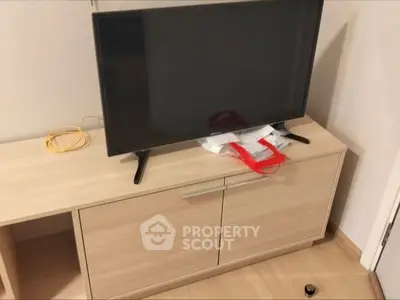 Modern living room with sleek TV on wooden cabinet, perfect for cozy entertainment.