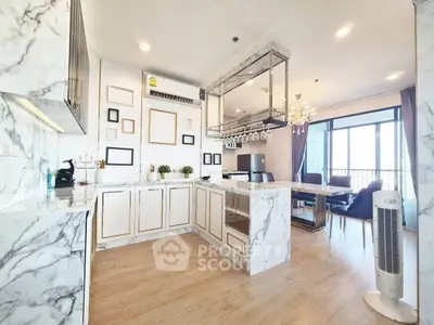 Luxurious open-layout kitchen with marble countertops and elegant dining area in modern apartment.