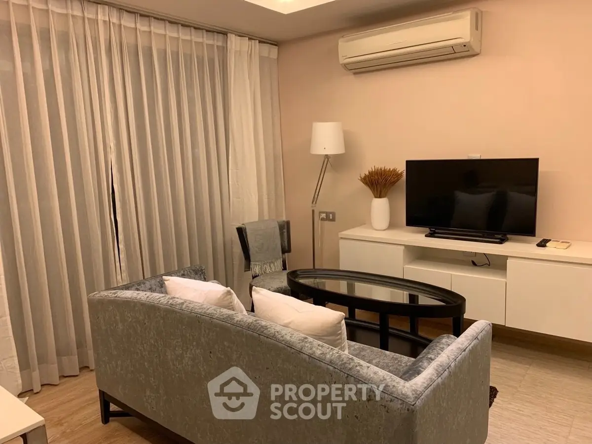 Cozy living room with modern furniture and air conditioning, perfect for relaxation.