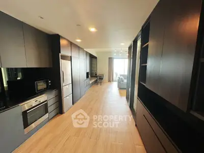 Modern kitchen with sleek cabinetry and open layout leading to living area
